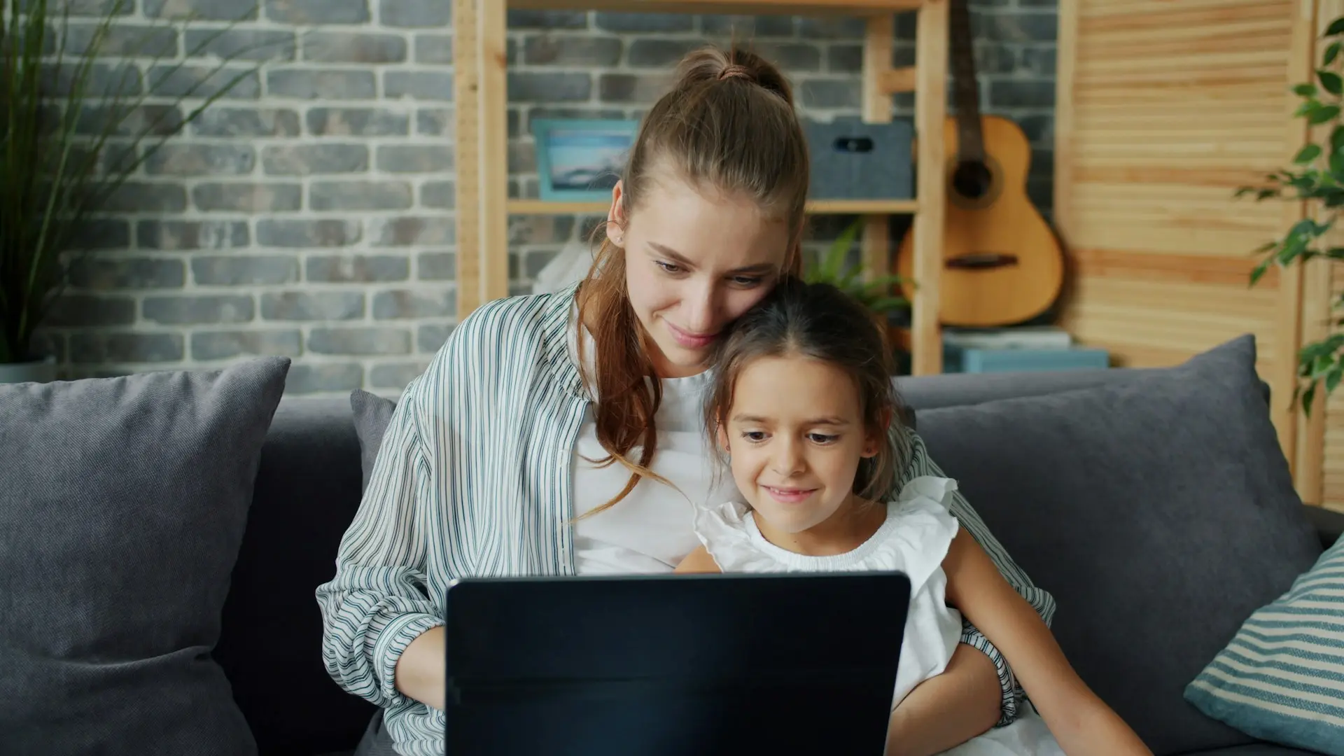 Madre e hija usando notebook reparada en Montevideo - servicio técnico Reparandola